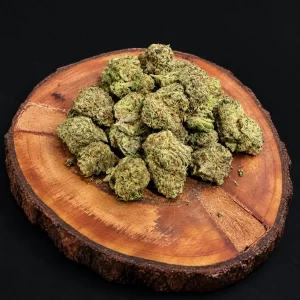 cannabis flower on top of a round wooden tray .