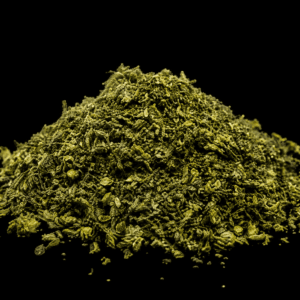 A pile of trimmed cannabis shake on a black background.