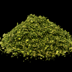 A pile of trimmed cannabis shake on a black background.